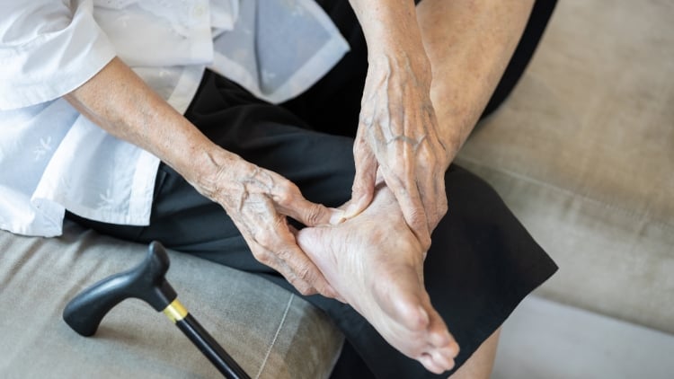 individual who suffers from neuropathy rubbing their feet