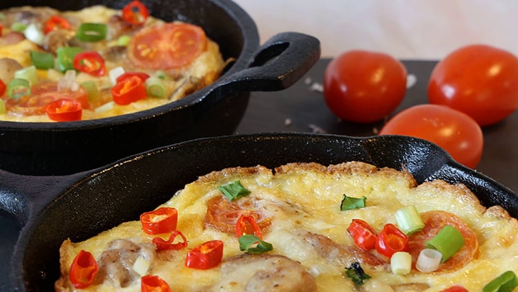 a vegetable omelet cooking in a skillet