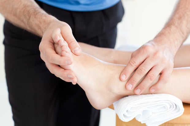 Close-up of a Woman having a foot massage against a white background
